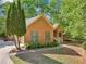 Brick home with manicured landscaping, blue shutters, and concrete walkway surrounded by trees at 318 Dogwood Trce, Mcdonough, GA 30252