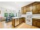 Open kitchen with stainless steel dishwasher, wood cabinets, and adjacent dining area with backyard view at 318 Dogwood Trce, Mcdonough, GA 30252