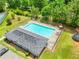 Aerial view of community pool with a fenced in area, lounge chairs and umbrellas at 3315 Brookfield Dr, Austell, GA 30106