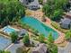Aerial view displays a serene pond, community pool, and tennis courts surrounded by mature trees and manicured landscapes at 4190 Madison Dr, Cumming, GA 30040