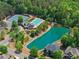 An aerial showcases a pool, tennis courts, a pond, and mature trees in a community setting at 4190 Madison Dr, Cumming, GA 30040