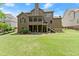 Large backyard featuring lush green lawn, deck, patio area, screened in porch, and home exterior at 4190 Madison Dr, Cumming, GA 30040