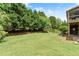 A grassy backyard has beautiful, mature trees and a portion of the house on the right at 4190 Madison Dr, Cumming, GA 30040