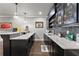 Basement wet bar featuring pendant lighting, dark cabinetry and an extended countertop with bar stools at 4190 Madison Dr, Cumming, GA 30040