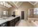 Bathroom with granite countertops, double sinks, soaking tub, and glass-enclosed shower at 4190 Madison Dr, Cumming, GA 30040
