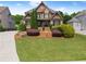 Charming two-story brick home with a manicured lawn, mature landscaping, and welcoming front porch at 4190 Madison Dr, Cumming, GA 30040