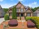 Inviting brick home featuring manicured shrubbery, lush green lawn, and charming front entrance at 4190 Madison Dr, Cumming, GA 30040