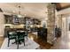 Open kitchen with dark wood cabinets, stone columns, breakfast nook, and stainless steel appliances at 4190 Madison Dr, Cumming, GA 30040