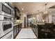 Well-lit kitchen featuring dark wood cabinetry, stainless steel appliances, granite counters, and stone column accents at 4190 Madison Dr, Cumming, GA 30040