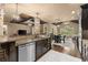 Kitchen island with granite countertops, dark wood cabinets, stone columns, and an open view to the Gathering room at 4190 Madison Dr, Cumming, GA 30040