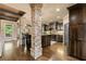 Spacious open kitchen with stone columns, dark wood cabinetry, granite countertops, and stainless steel appliances at 4190 Madison Dr, Cumming, GA 30040