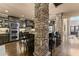 Open kitchen with stone columns, dark wood cabinetry, a kitchen island with bar stools, and stainless appliances at 4190 Madison Dr, Cumming, GA 30040