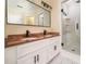 Bathroom featuring a double vanity with granite countertops, white cabinets, a large mirror, and a glass-enclosed shower at 440 Hickory Glen Sw Ln, Atlanta, GA 30311