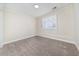Neutral bedroom featuring carpet, baseboards, and a shuttered window at 440 Hickory Glen Sw Ln, Atlanta, GA 30311
