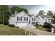 Charming home with an attached garage, landscaped front yard, and a bright orange front door on a sunny day at 440 Hickory Glen Sw Ln, Atlanta, GA 30311