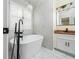 Bright bathroom featuring a standalone tub, white marble, a faucet and vanity with white cabinets and dark fixtures at 440 Hickory Glen Sw Ln, Atlanta, GA 30311