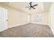 Spacious main bedroom featuring plush carpeting, a tray ceiling with a fan, and a window with white shutters at 440 Hickory Glen Sw Ln, Atlanta, GA 30311