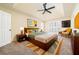 View of furnished main bedroom, featuring plush carpeting, a tray ceiling with a fan, and a window with white shutters at 440 Hickory Glen Sw Ln, Atlanta, GA 30311