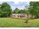 Fenced backyard showcasing the home's exterior and well-manicured lawn with mature trees at 6292 Field Glen Rd, Stone Mountain, GA 30087