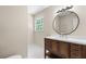 Bathroom featuring a sleek vanity with a round mirror and modern lighting fixtures, complemented by tile flooring at 6292 Field Glen Rd, Stone Mountain, GA 30087