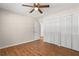 Bedroom features attractive wood flooring, a ceiling fan, and double closets for ample storage at 6292 Field Glen Rd, Stone Mountain, GA 30087