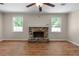 Cozy living room features a stone fireplace, wood-look flooring, and bright natural light from the windows at 6292 Field Glen Rd, Stone Mountain, GA 30087