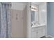 Bathroom features a shower with floral curtain, a white vanity and a light fixture at 2675 Paul Thomas Dr, Dacula, GA 30019