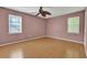 Bedroom features stylish pink walls, hardwood floors, ceiling fan and two windows at 2675 Paul Thomas Dr, Dacula, GA 30019