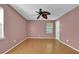 Bedroom features stylish pink walls, hardwood floors, ceiling fan and a window at 2675 Paul Thomas Dr, Dacula, GA 30019