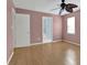 Bedroom features stylish pink walls, hardwood floors, ceiling fan and a door to the bathroom at 2675 Paul Thomas Dr, Dacula, GA 30019