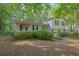 Charming two-story home featuring an inviting front porch, wood siding, and a double garage in a serene wooded setting at 2675 Paul Thomas Dr, Dacula, GA 30019