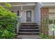 Inviting front porch with stairs leading to a stylish front door and lush greenery at 2675 Paul Thomas Dr, Dacula, GA 30019