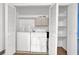 Bright laundry room with washer, dryer, shelves, and storage cabinets at 2675 Paul Thomas Dr, Dacula, GA 30019