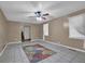 Bright living room with neutral walls, tile flooring, ceiling fan, and large windows at 2675 Paul Thomas Dr, Dacula, GA 30019