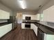 Well-lit kitchen with stainless steel appliances, white cabinets, and dark countertops at 3063 Grace Ct, Lawrenceville, GA 30043