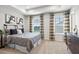 Comfortable bedroom with a patterned comforter, two windows with decoratice curtains, and neutral carpet at 3078 Hudson Glen Way, Dacula, GA 30019