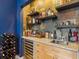 Stylish bar area with open shelving, granite countertops, beverage fridge, and blue accent wall at 325 E Paces Ferry Ne Rd # 602, Atlanta, GA 30305