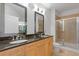Bright bathroom featuring a double vanity with granite countertop, custom cabinetry, and a glass-enclosed shower at 325 E Paces Ferry Ne Rd # 602, Atlanta, GA 30305