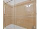 This shower features a glass door, tan tile and a white bathtub at 325 E Paces Ferry Ne Rd # 602, Atlanta, GA 30305