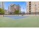 Well-maintained tennis court with green and blue surfacing, surrounded by lush greenery and urban buildings at 325 E Paces Ferry Ne Rd # 602, Atlanta, GA 30305