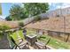 Beautiful backyard with a patio featuring a fire pit and chair set, surrounded by a green lawn, and mature trees at 409 Norton Xing, Woodstock, GA 30188