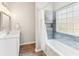 Bathroom featuring a bathtub with tile surround, vanity, and a modern mirror at 409 Norton Xing, Woodstock, GA 30188
