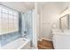 Bright bathroom with a shower and bathtub combo, light blue subway tile, and a stylish vanity with new fixtures at 409 Norton Xing, Woodstock, GA 30188