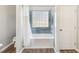 Bathroom featuring a bathtub with tile surround and window at 409 Norton Xing, Woodstock, GA 30188