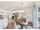 Elegant dining area with a modern light fixture, a view into the kitchen, and a sliding door at 409 Norton Xing, Woodstock, GA 30188