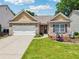 Charming brick home with a well-manicured lawn, inviting front porch, and a two-car garage at 409 Norton Xing, Woodstock, GA 30188