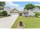 Charming home featuring a well-manicured lawn, colorful garden beds, and a two-car garage at 409 Norton Xing, Woodstock, GA 30188