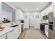 Beautiful kitchen with white cabinets, stainless steel appliances, quartz countertops, and a mosaic tile backsplash at 409 Norton Xing, Woodstock, GA 30188