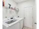Neat laundry room with modern, white front-loading washer and dryer, and wire shelving for storage at 409 Norton Xing, Woodstock, GA 30188