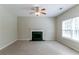 A spacious living room has neutral carpet, a fireplace, and a light-filled window at 4870 Heather Mill Trce, Snellville, GA 30039